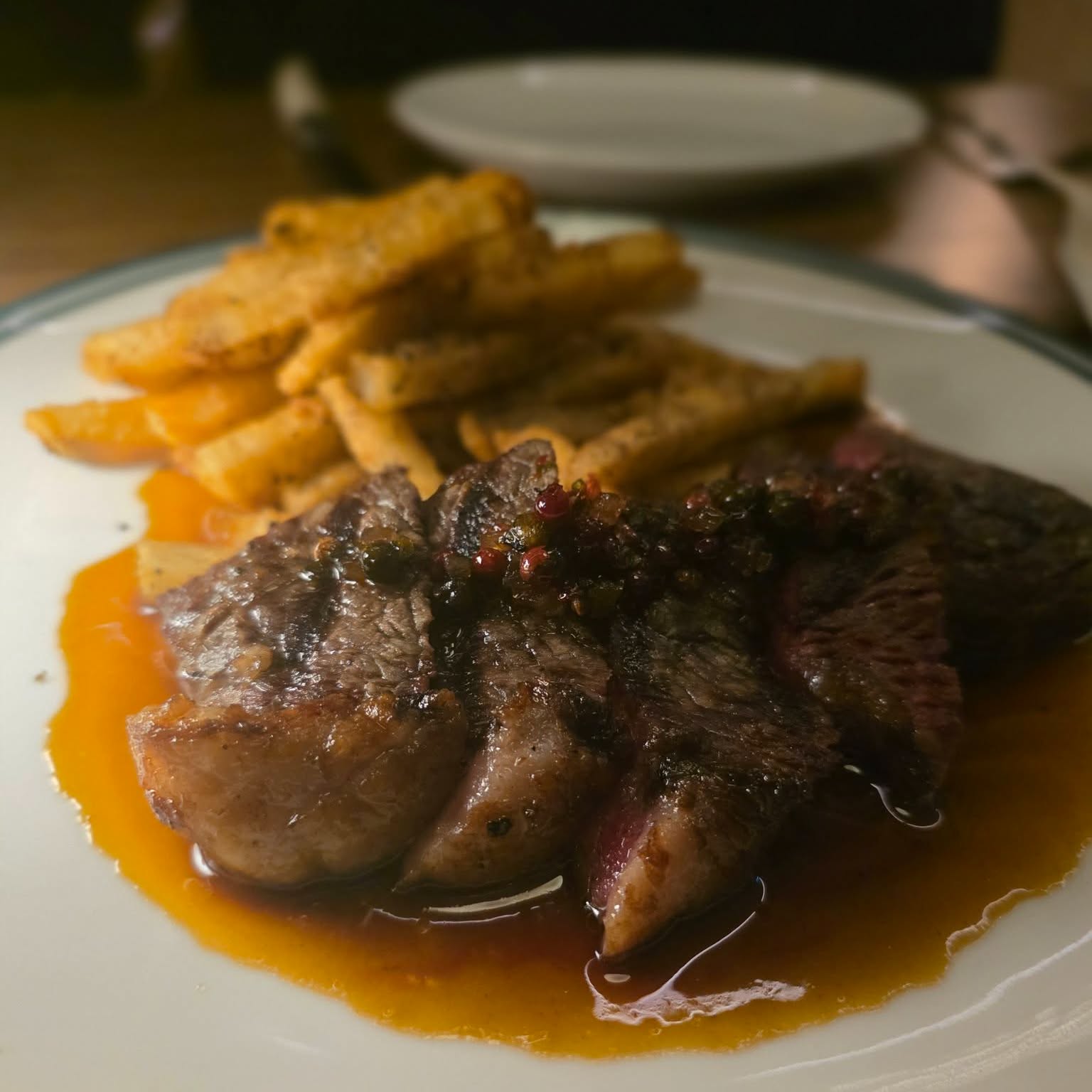 Steak frites, au poivre, cognac and green peppercorn sauce.