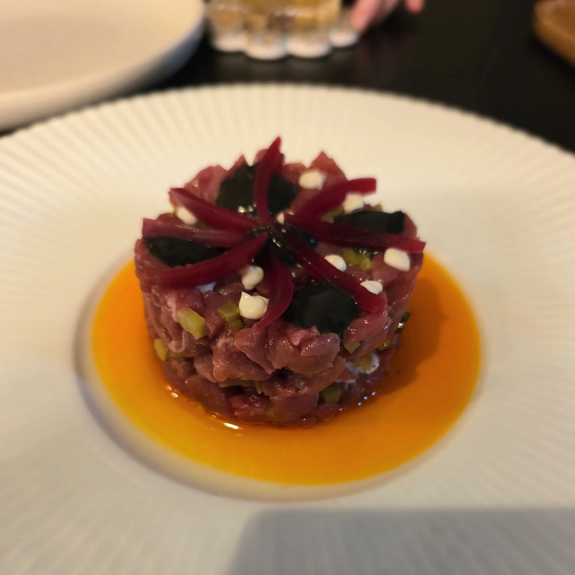Beef rump cap tartare, black bagna cauda mayo, stracciatella, chilli oil, flatbread chard, pickled cocktail onions.