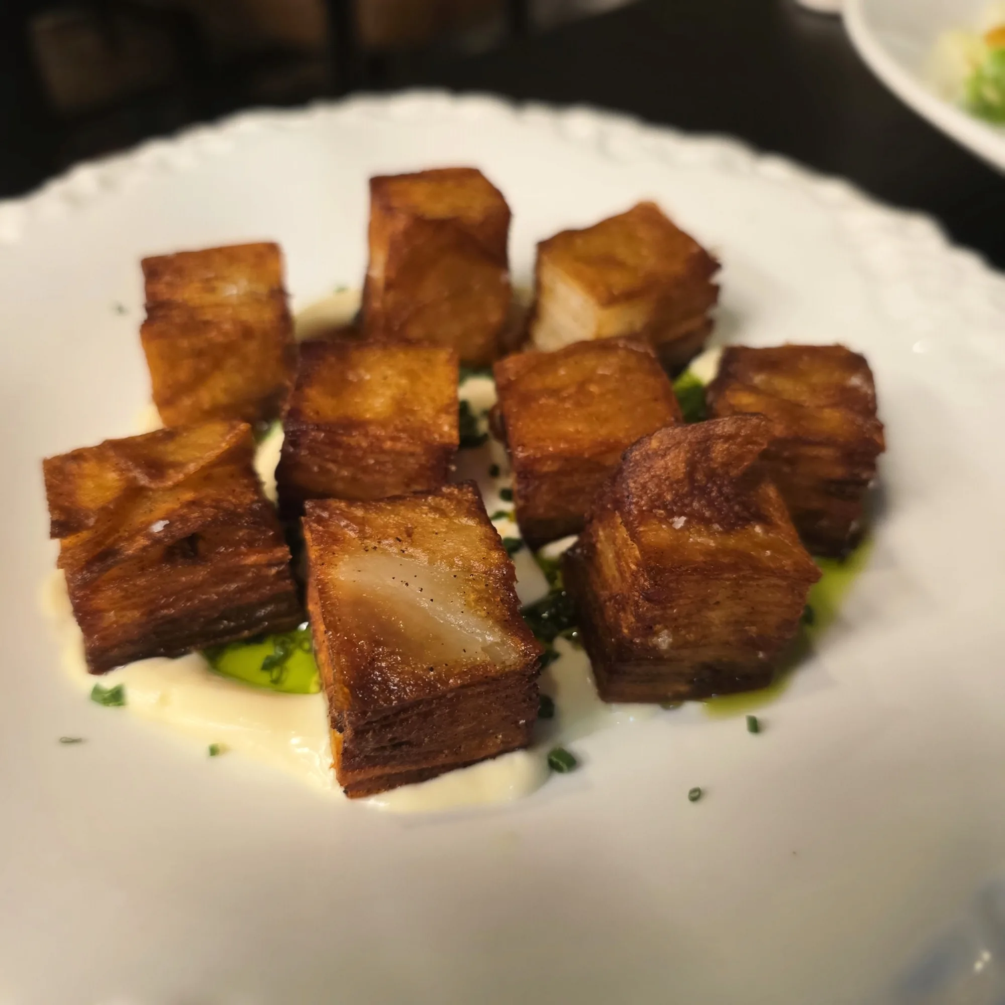 Crispy potato layers, duck fat, smoked cr&egrave;me fra&icirc;che, chilli oil, chives.