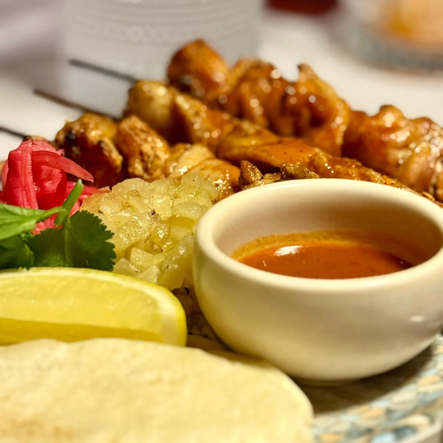 Grilled chicken skewers with pickled onion, charred pineapple, herbs, flat bread and red pepper sauce