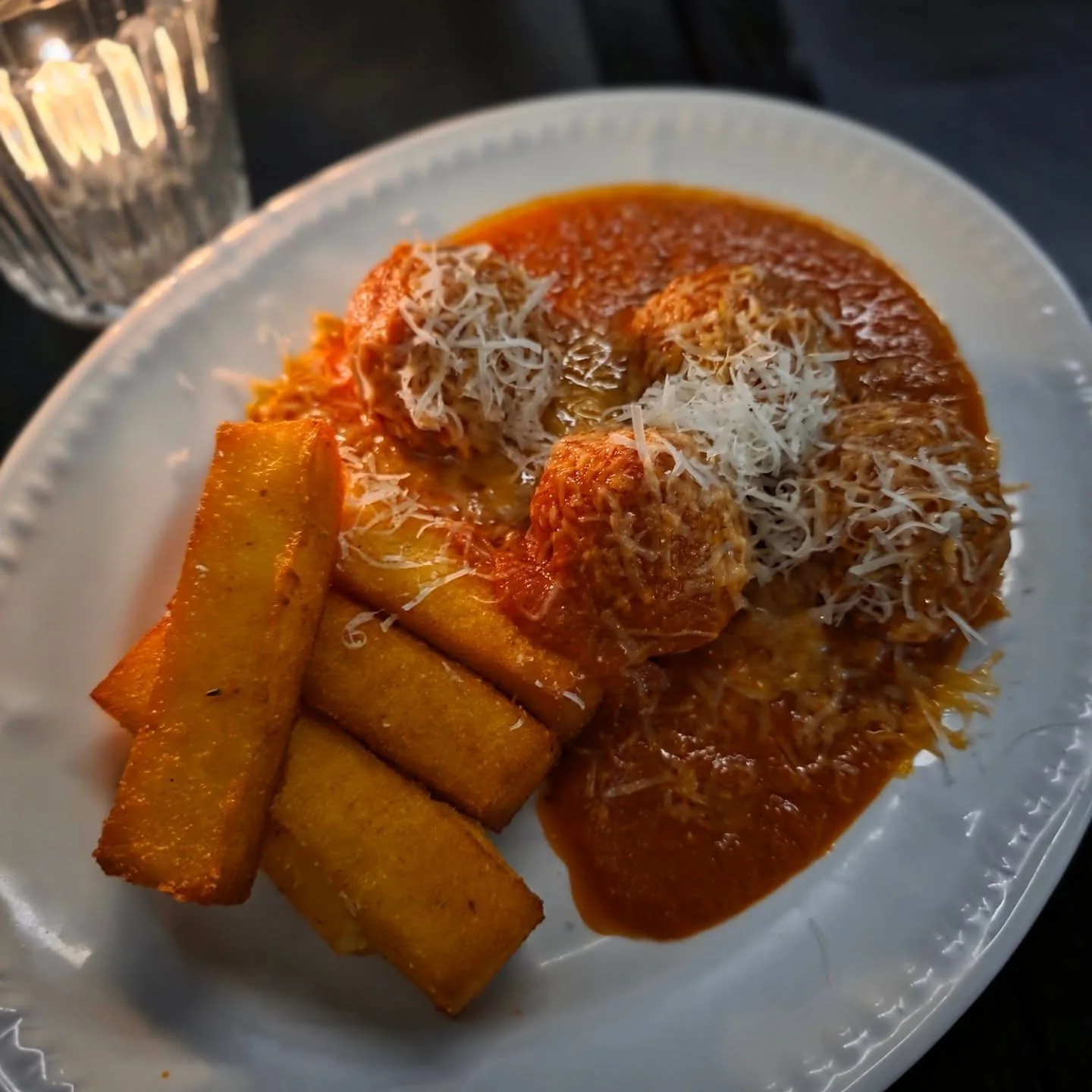 Italian style meatballs in tomato sugo with crispy polenta and parmigiano
